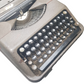 Image of Hermes Baby Old Typewriter. Portable Typewriter. Original Dark Grey. Swiss Made. Available with cover. Available from universaltypewritercompany.in